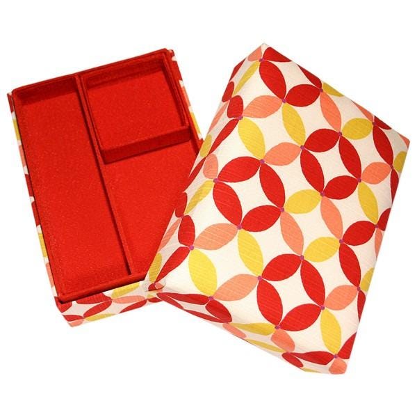 an open red and white box with a pattern of red and yellow circles on its surface.