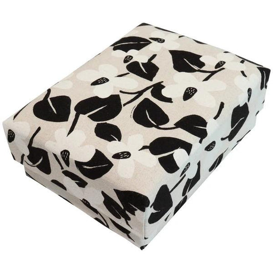 A square-shaped box with a black and white floral pattern on its surface.