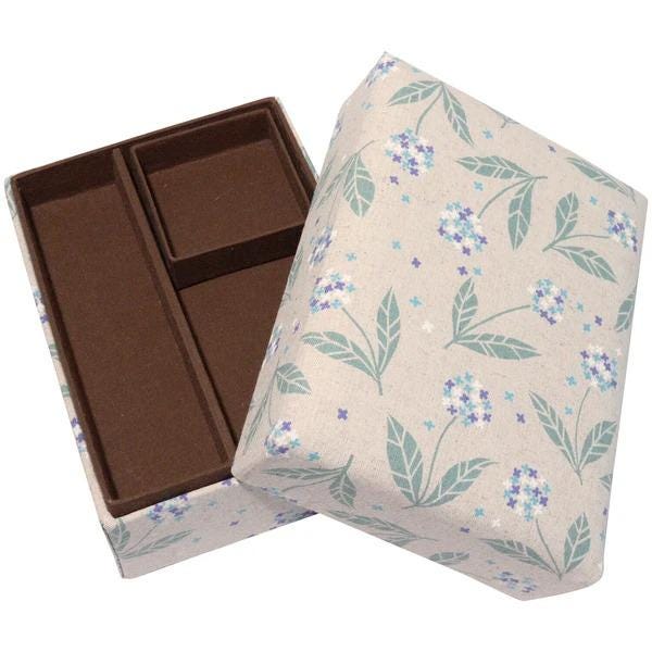 a beige box with a floral pattern, featuring two empty compartments.