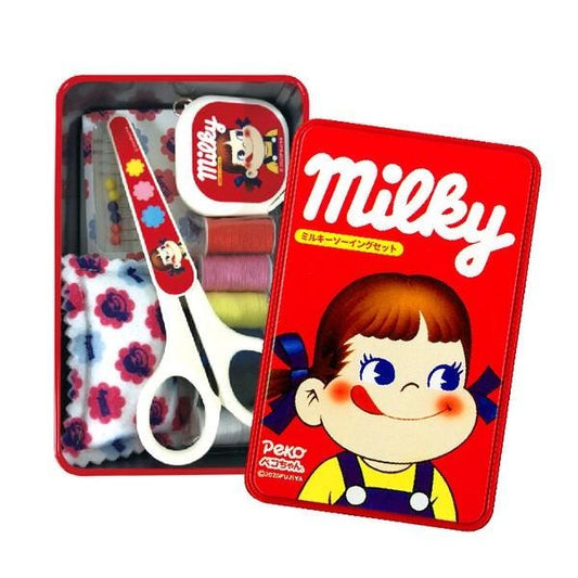 A red tin box containing various sewing and crafting supplies, including a pair of scissors, a sewing kit, and a character design.