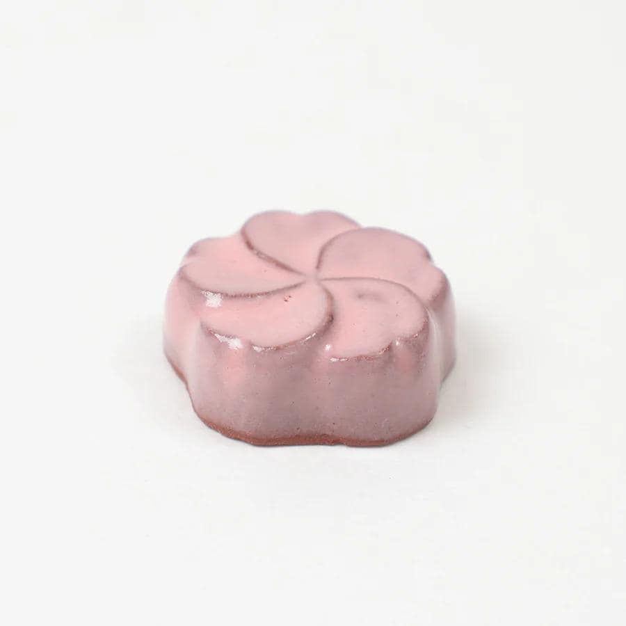 A pink flower-shaped object is sitting on a white background.