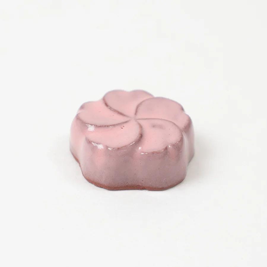 A pink flower-shaped object is sitting on a white background.