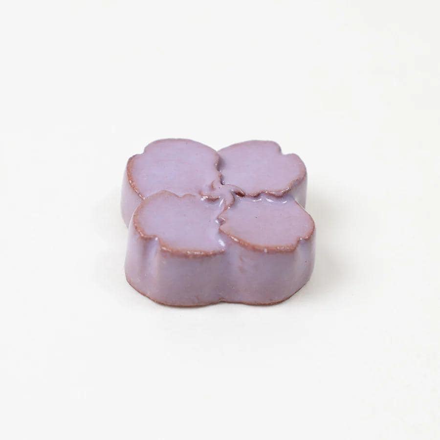 A single, purple-colored object resembling a flower or leaf shape is shown against a white background.