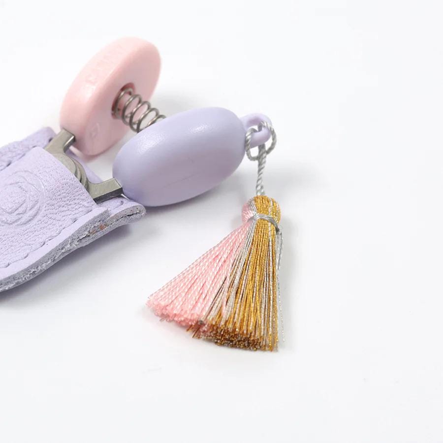 A purple keychain with a tassel attached, resting on a white surface.