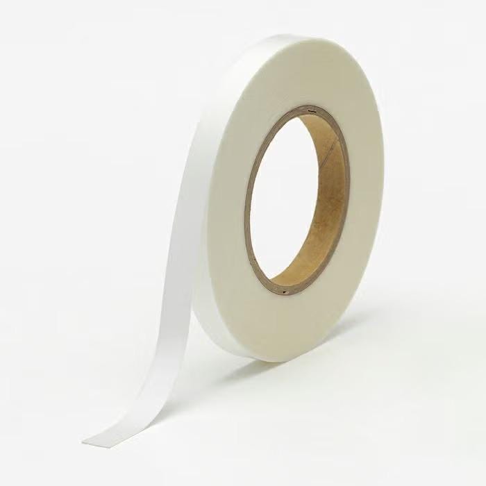 A roll of white adhesive tape is shown against a plain white background.