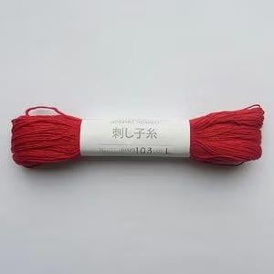 A spool of red yarn with Japanese text on it.