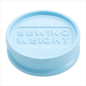 A light blue, circular object with the text "SEWING WEIGHT" embossed on it.