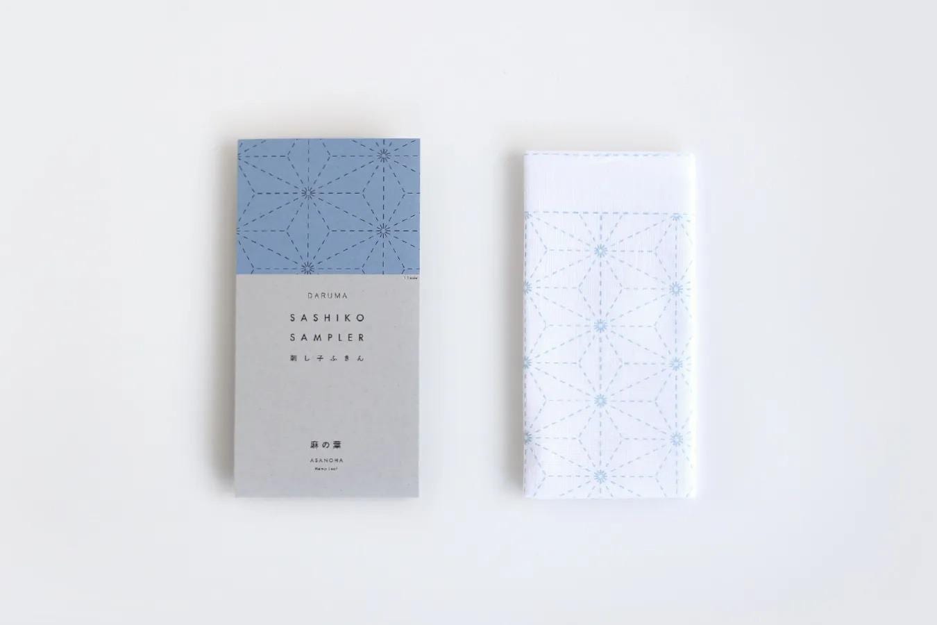 two fabric items with a geometric pattern, one blue and one white, placed side by side against a white background.