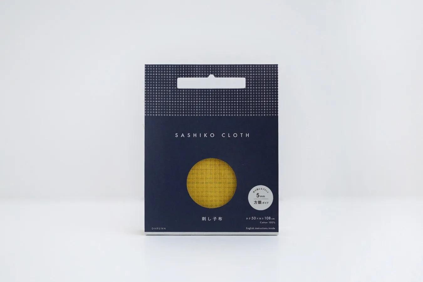 A package of Sashiko cloth, which is a type of fabric. The package is predominantly blue and white in color, with a yellow circle in the center. The text on the package indicates that it is a product of Daruma, and it is 5.50 meters in length.