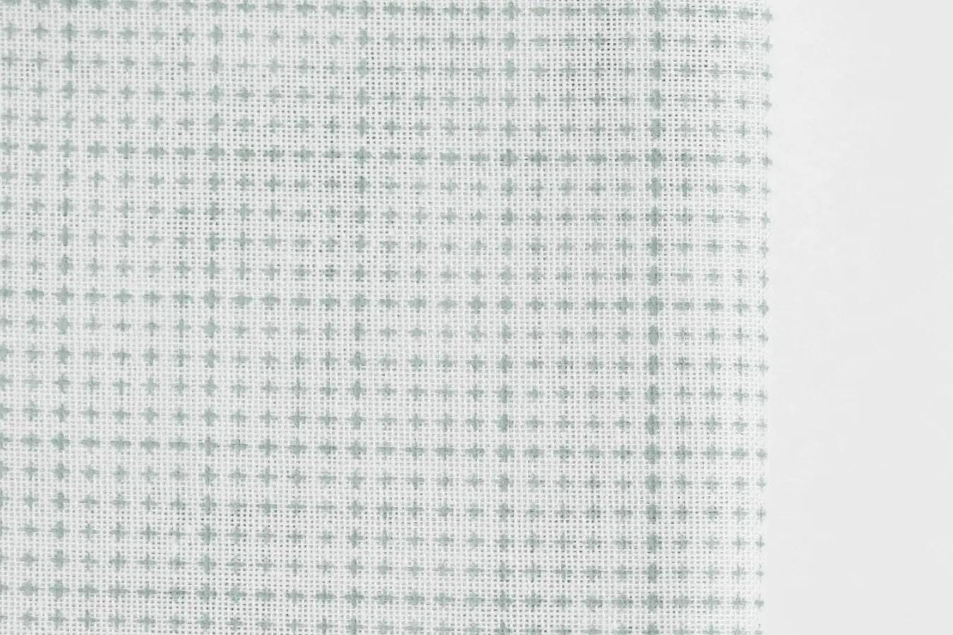a close-up view of a fabric with a grid-like pattern of small white dots or stars, creating a textured and visually interesting surface.