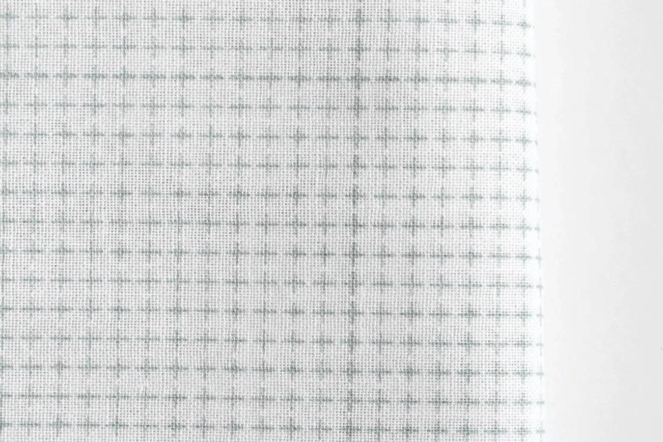 a close-up view of a fabric with a grid-like pattern of small squares or rectangles, creating a textured and visually interesting surface.