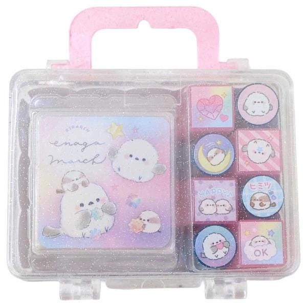 A clear plastic case with a pink handle, containing a set of colorful stamp blocks and a booklet with illustrations of cute animals.