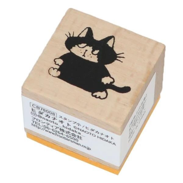 A wooden stamp with a black cat illustration on it.