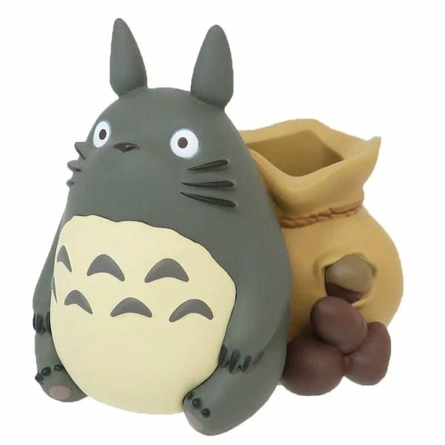 A gray and yellow figurine of a cat-like creature with large eyes and a small bag.
