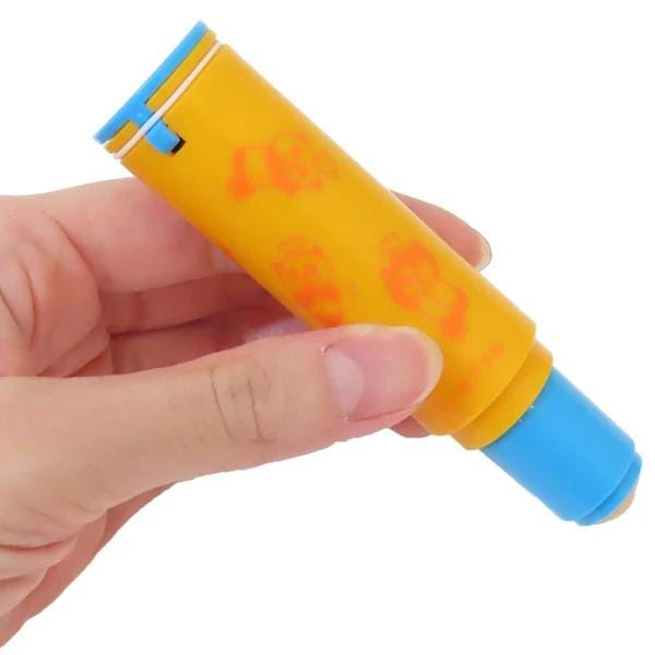 A hand holding a yellow and blue object with a blue cap, which appears to be a marker or pen.