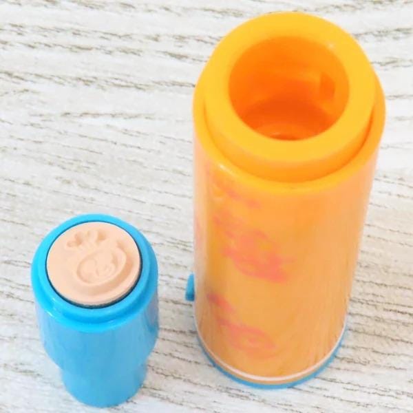 a blue and orange object, possibly a container or tool, placed on a white surface.