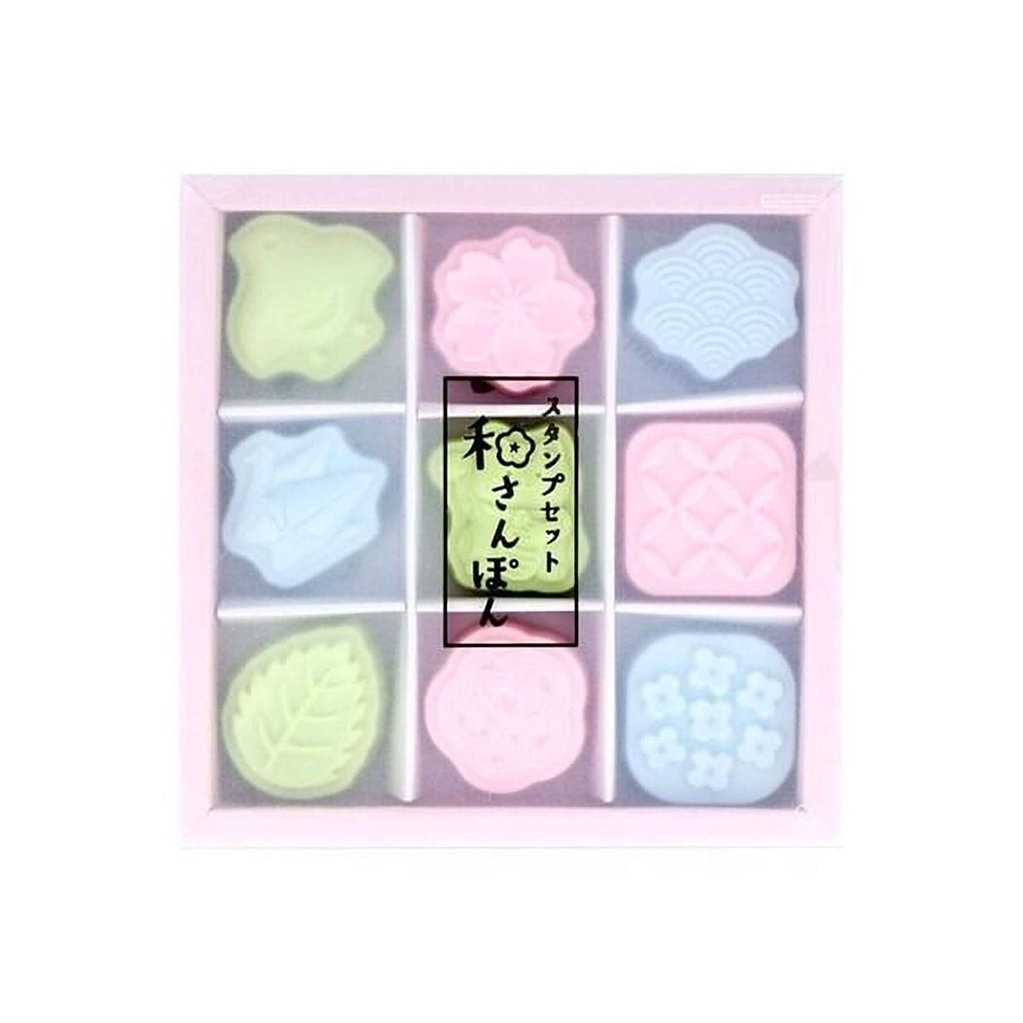 A pink box containing nine colorful, pastel-colored shapes, including a flower-shaped object, a leaf-shaped object, and other abstract shapes.