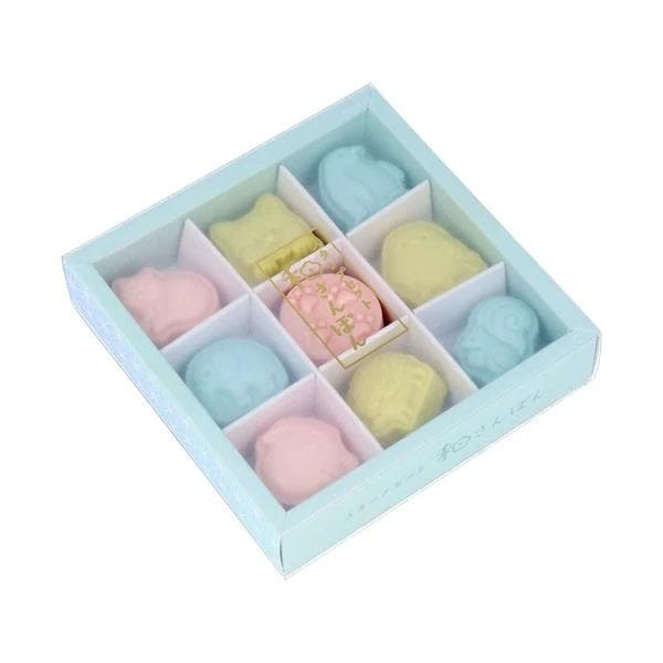 A light blue box containing nine colorful gummy bears in various pastel shades, including pink, blue, yellow, and green.