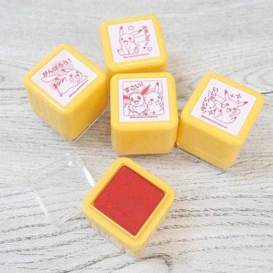 a collection of yellow and red Pokemon-themed stampers on a wooden surface.
