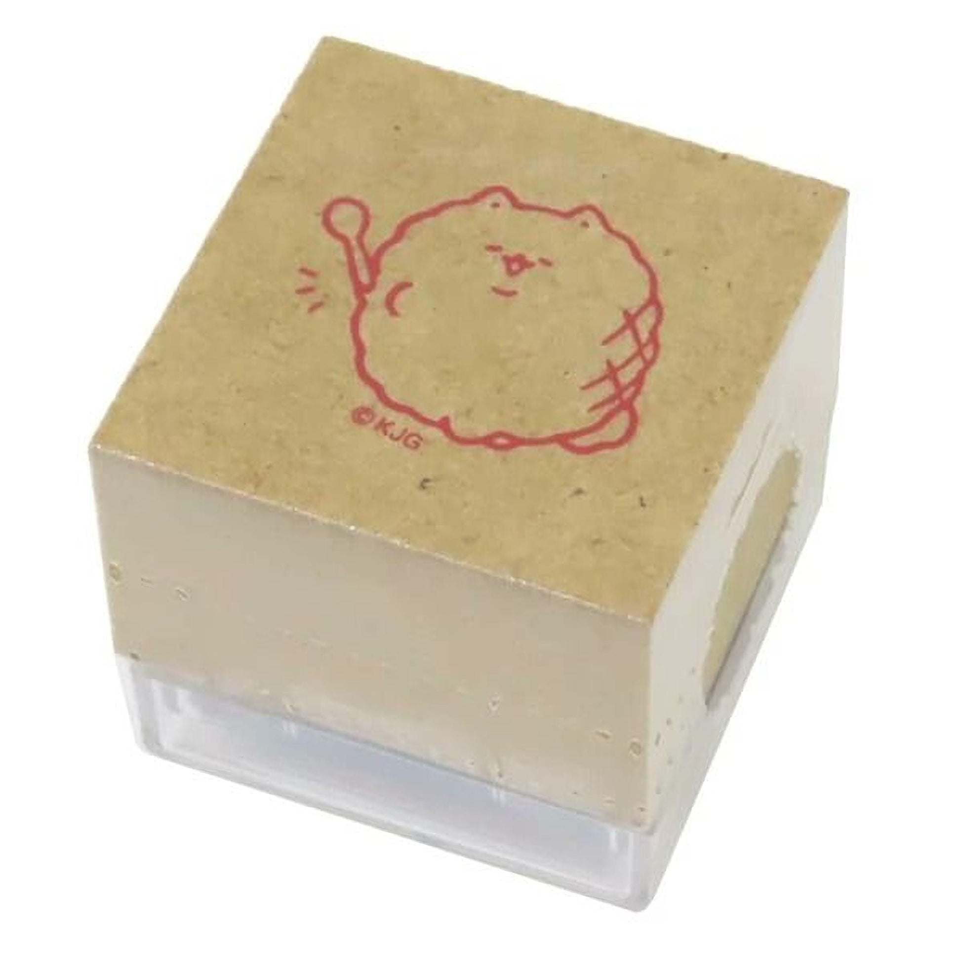 A square rubber stamp with a cartoon character printed on it.