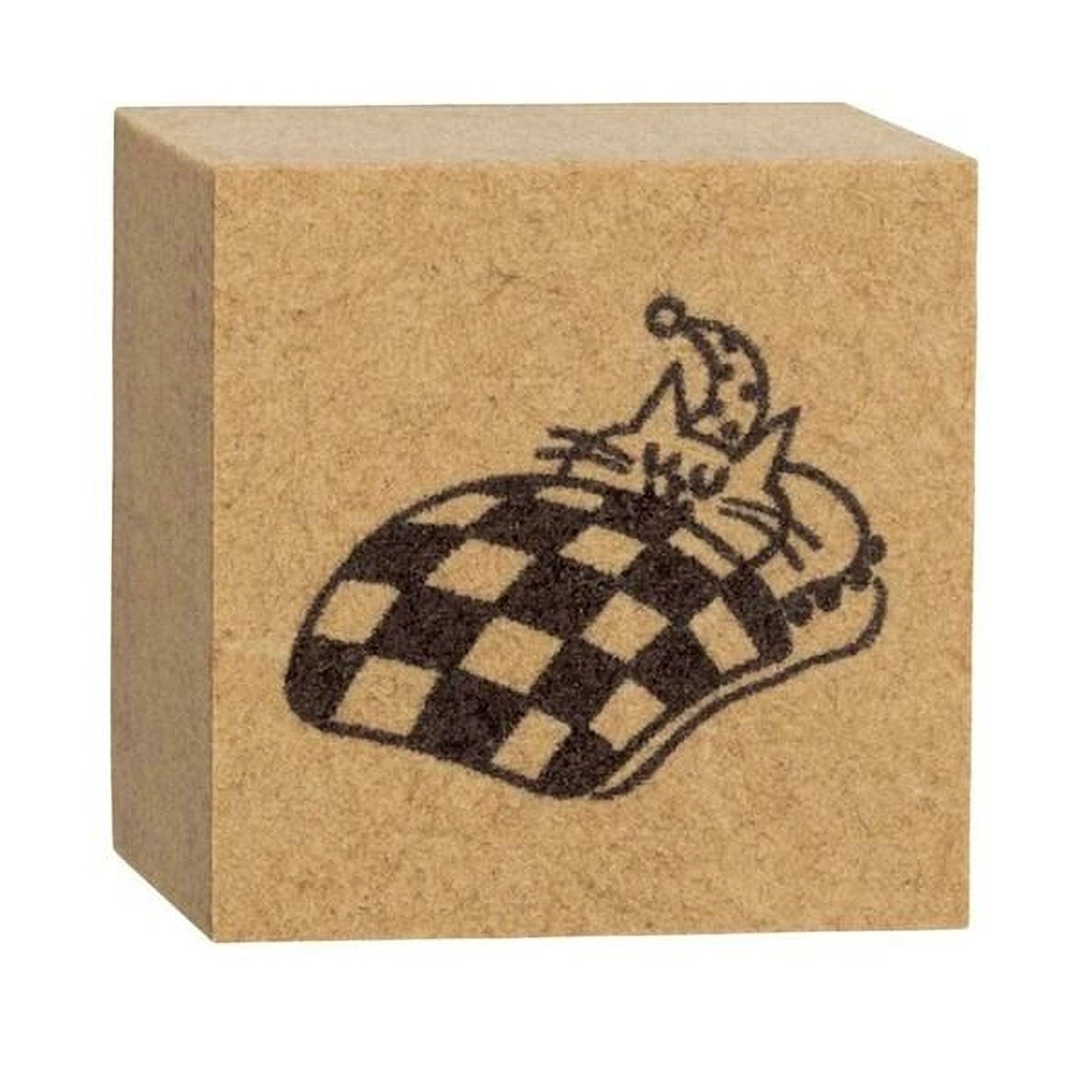 A square block with a black and white checkered pattern and a small cat sleeping on top of it.