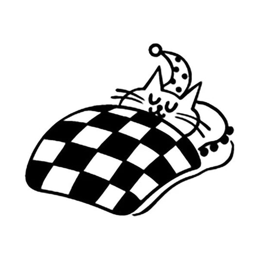 A cat is sleeping on a bed with a checkered blanket.
