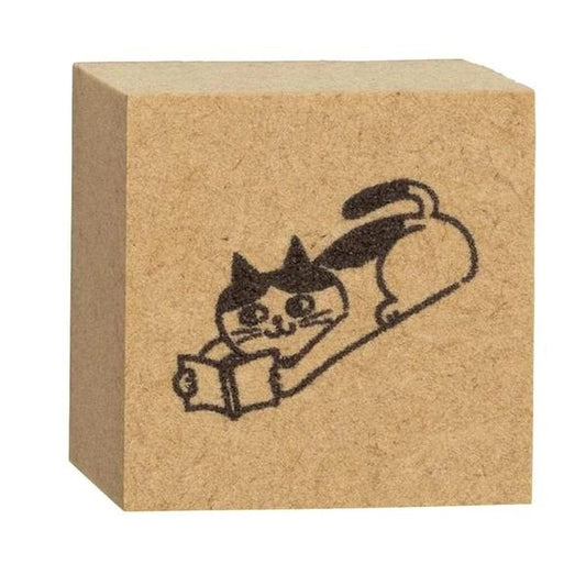 A block of brown cardboard with a black and white illustration of a cat reading a book.