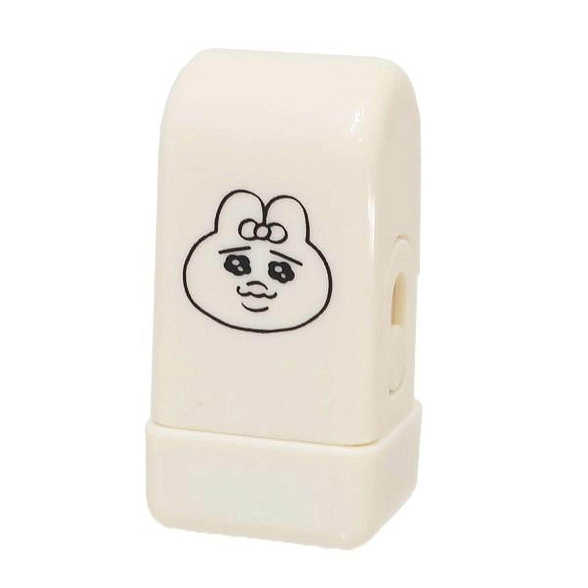 A white, rectangular object with a black cartoon character design on it.