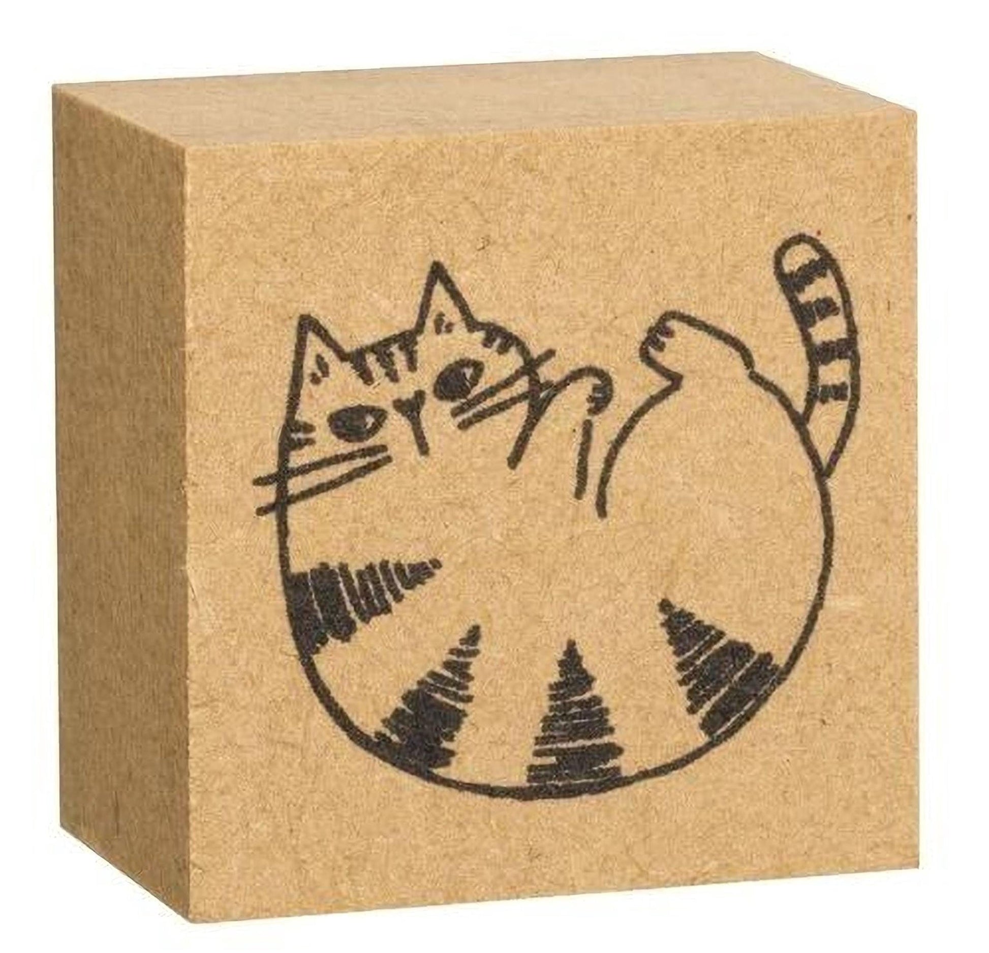 A square block with a black and white illustration of a cat on it.
