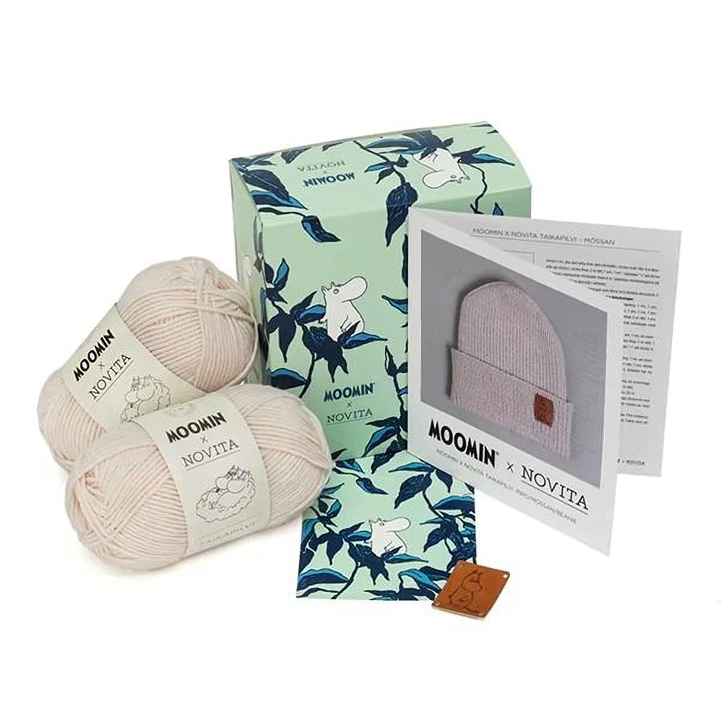 a collection of knitting supplies, including yarn, a box, and a booklet, all related to the Moomin brand.