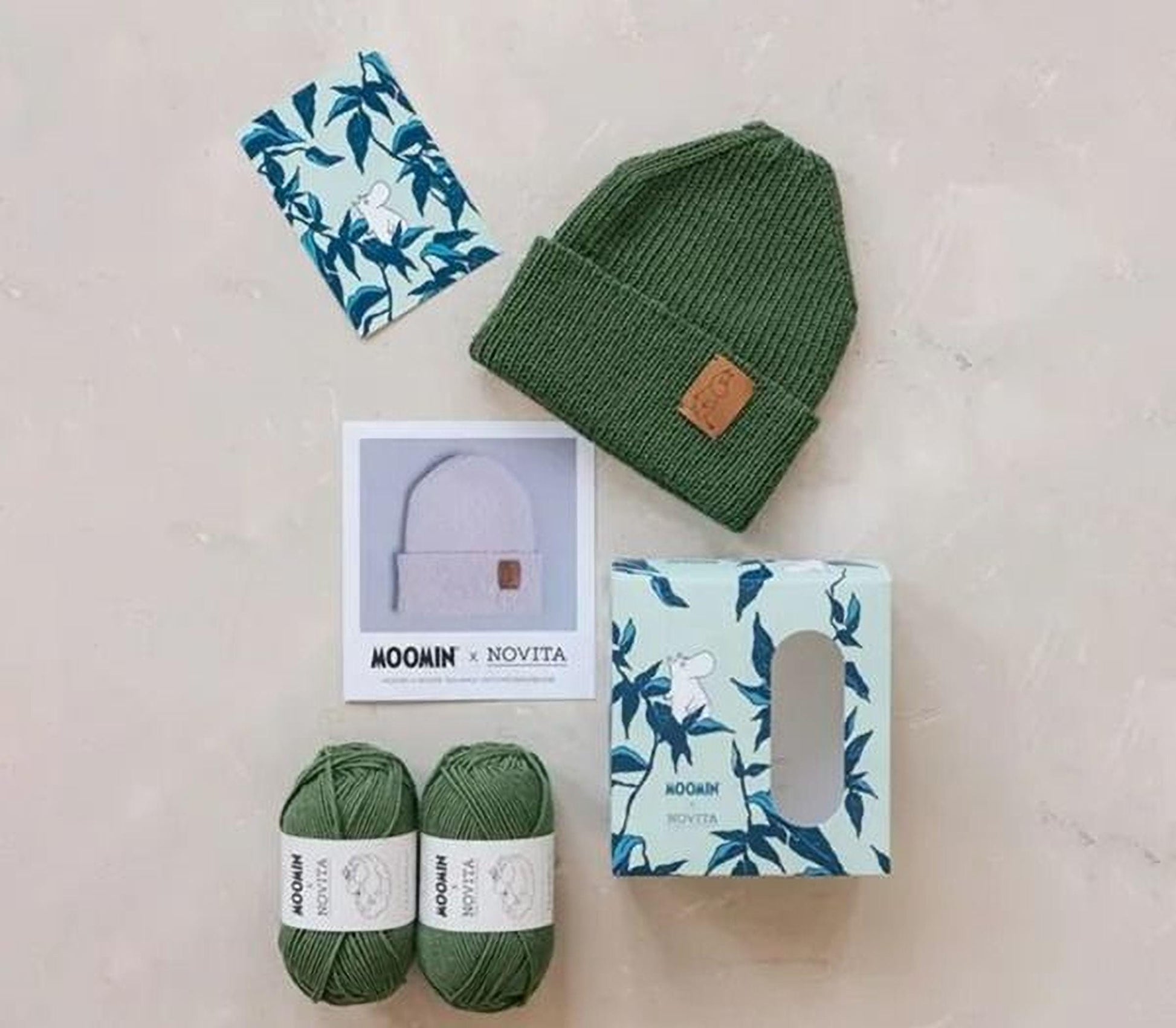 various items related to knitting and crafting, including a green knit hat, two balls of green yarn, a box of yarn, and a picture of a knit hat.