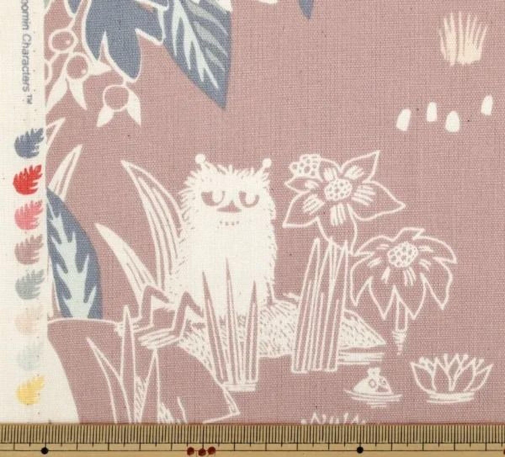 a whimsical scene with a cat sitting amidst various plants and flowers, with a ruler placed in front of the image.