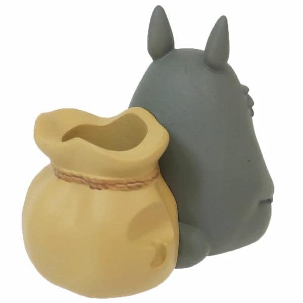 A gray toy figurine with a yellow bag attached to it.