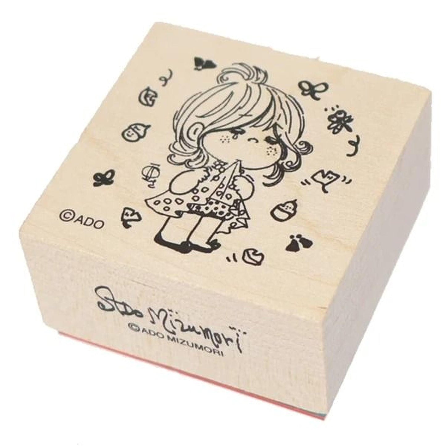 A wooden stamp featuring a cartoon illustration of a young girl with curly hair and a polka dot dress.