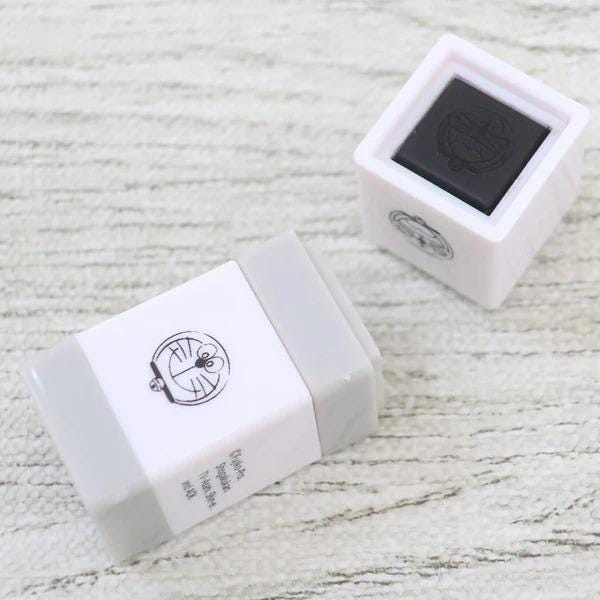 two white and gray boxes with black text and logos, placed on a textured surface.