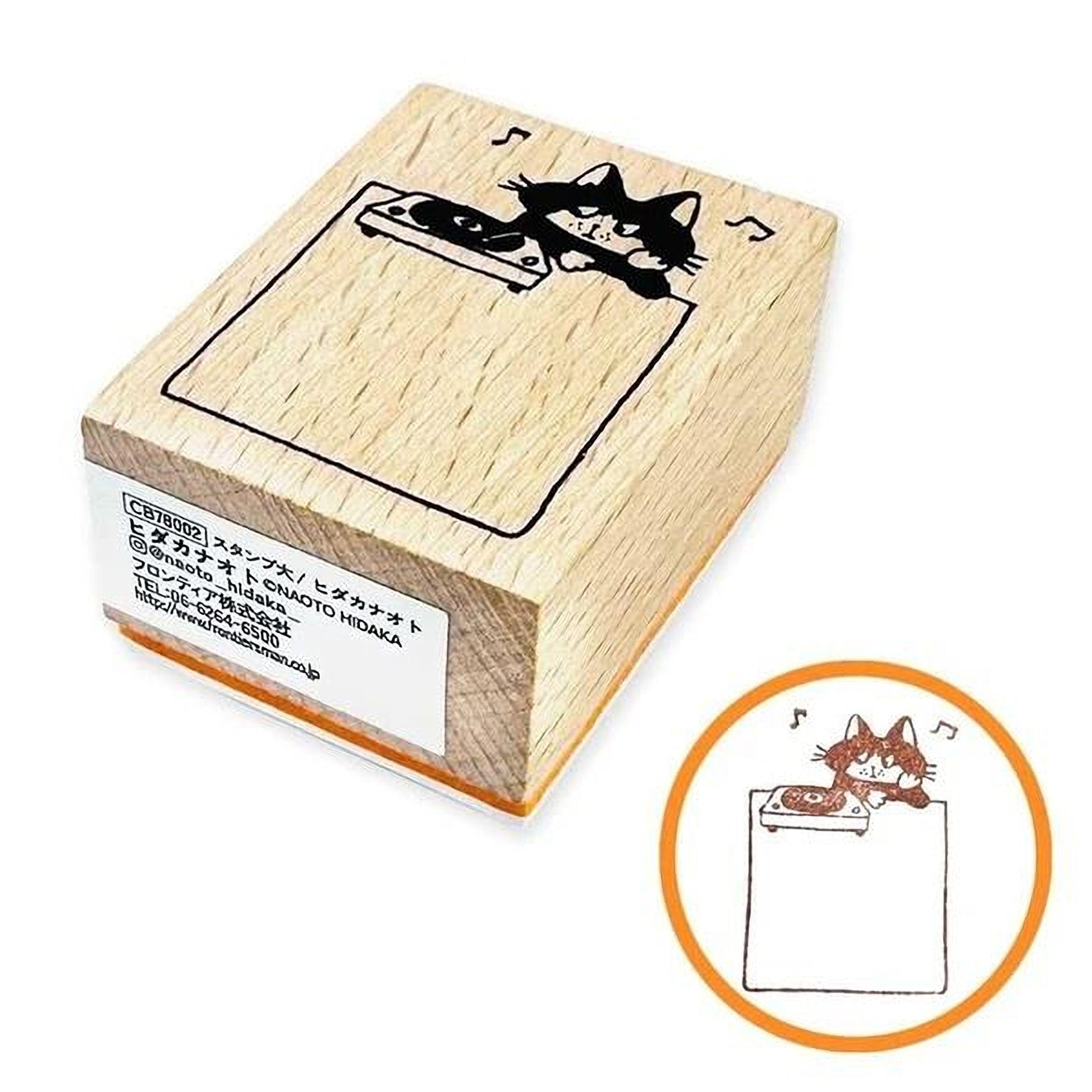 A wooden stamp with a cat illustration on it, along with a smaller circular stamp featuring a cat illustration.