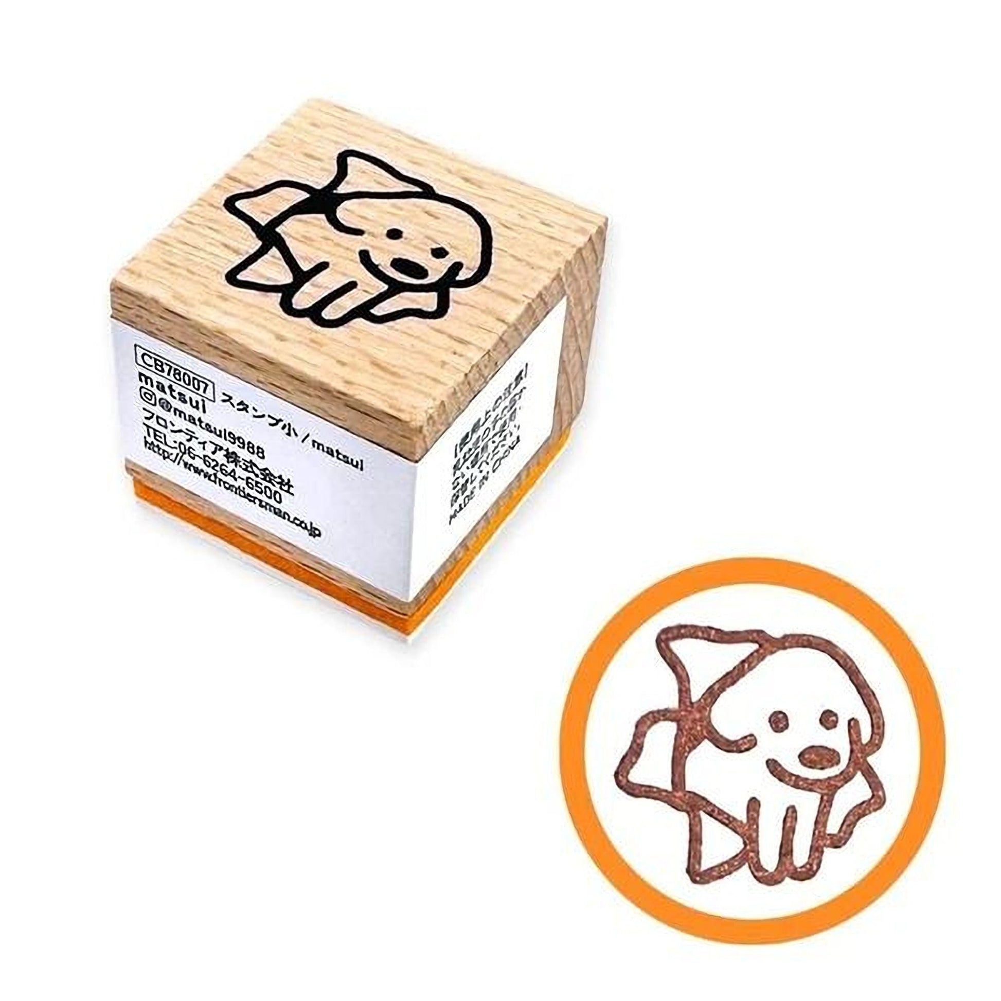 a wooden stamp with a cartoon dog design, and there is a smaller circular stamp with a similar dog design.