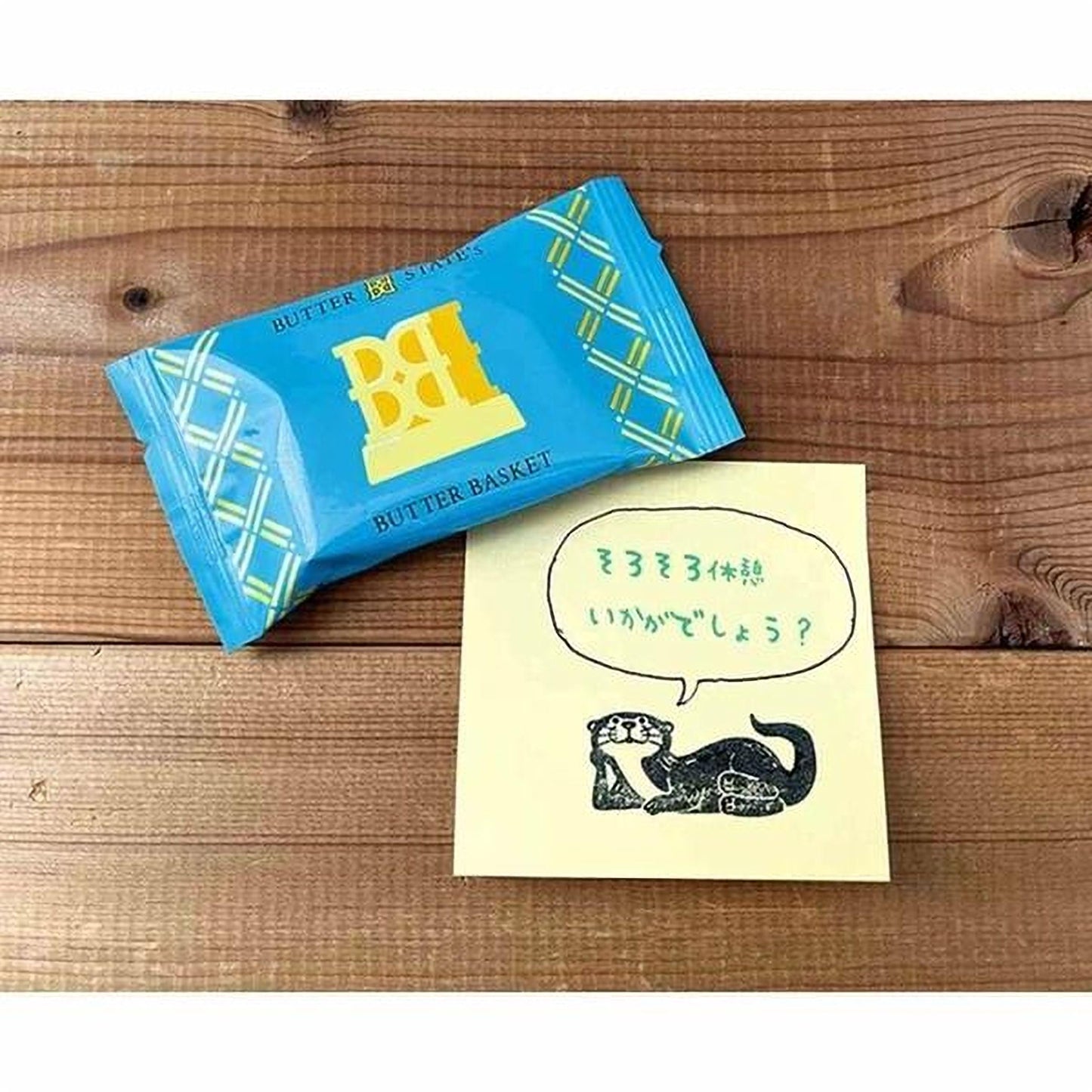 a blue package of Butter Basket and a yellow sticky note with a drawing of an otter and some Japanese text.
