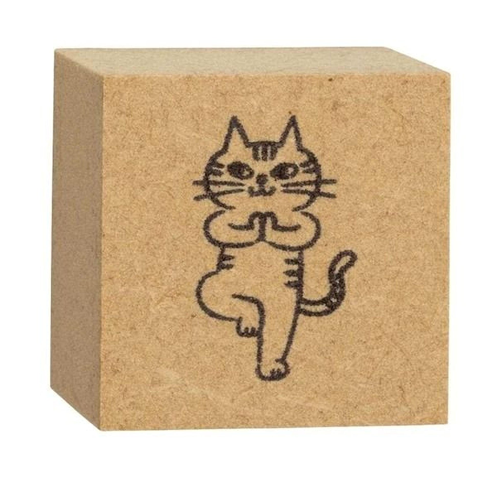A square wooden block with a simple black line drawing of a cat on it.