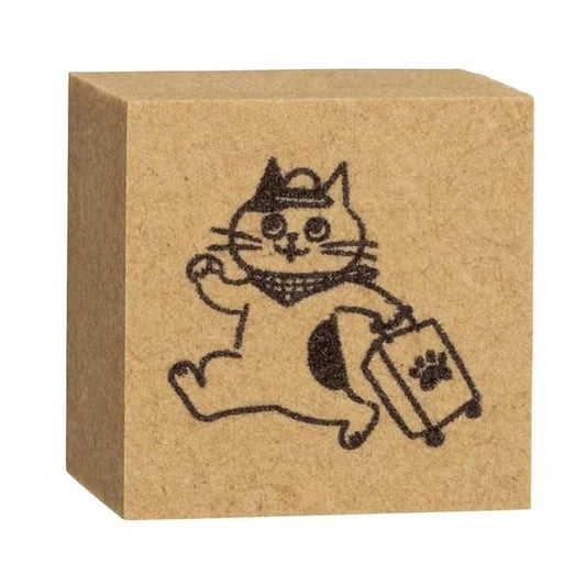 A square rubber stamp featuring a cartoon cat holding a suitcase and wearing a hat.