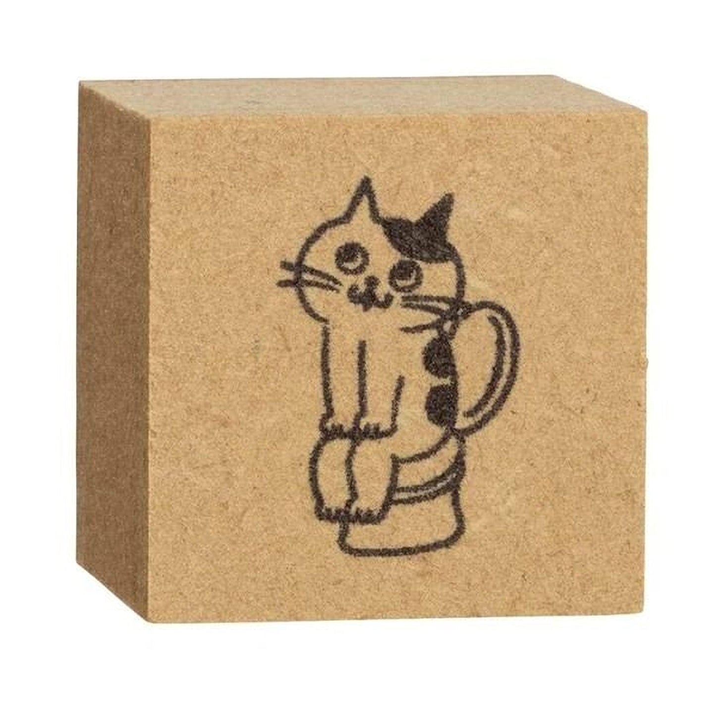 A square wooden block with a black and white drawing of a cat sitting on a toilet.
