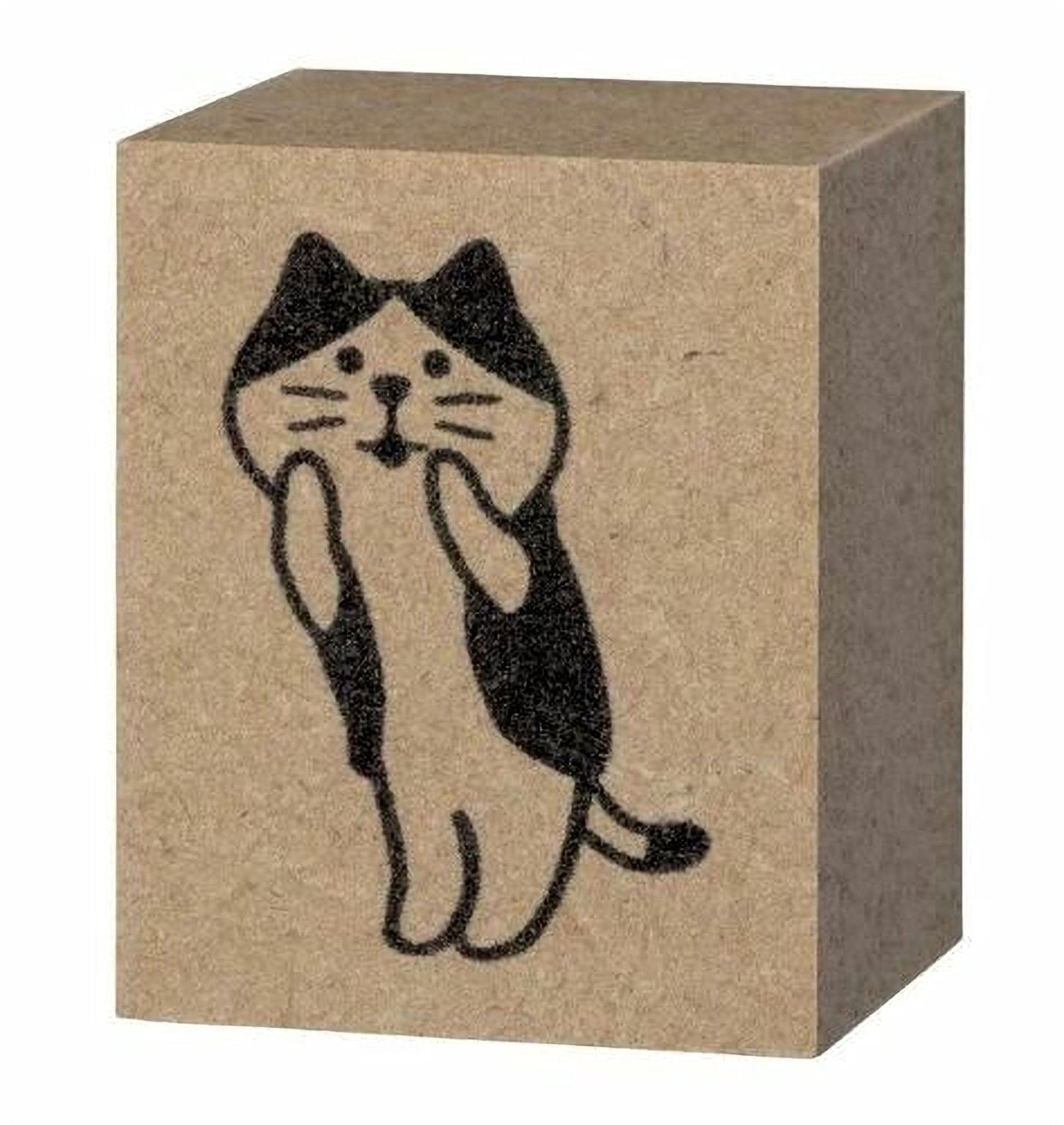 A block of brown cardboard with a black and white illustration of a cat on it.