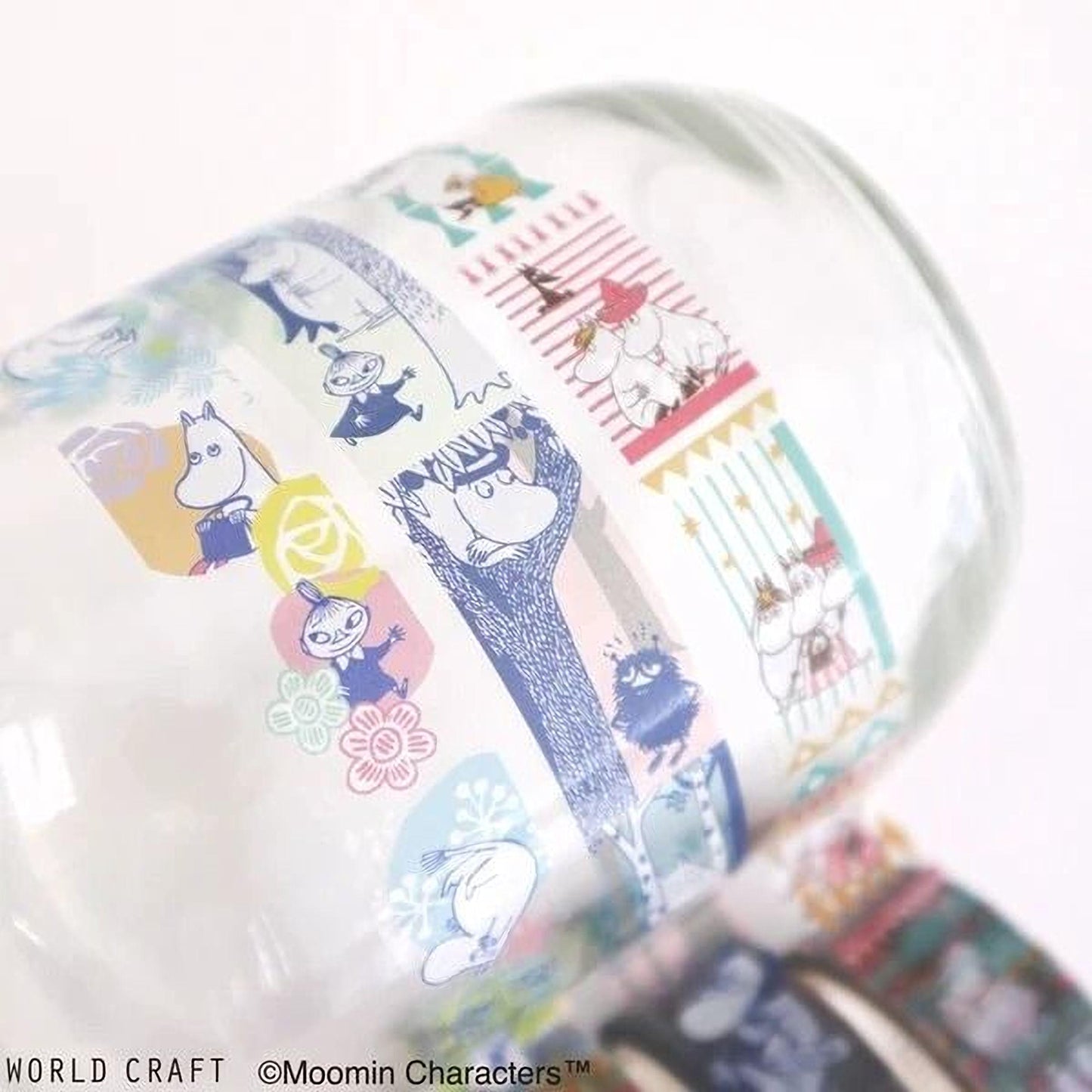 A close-up view of a glass mug with a colorful, patterned design featuring various cartoon characters and illustrations.