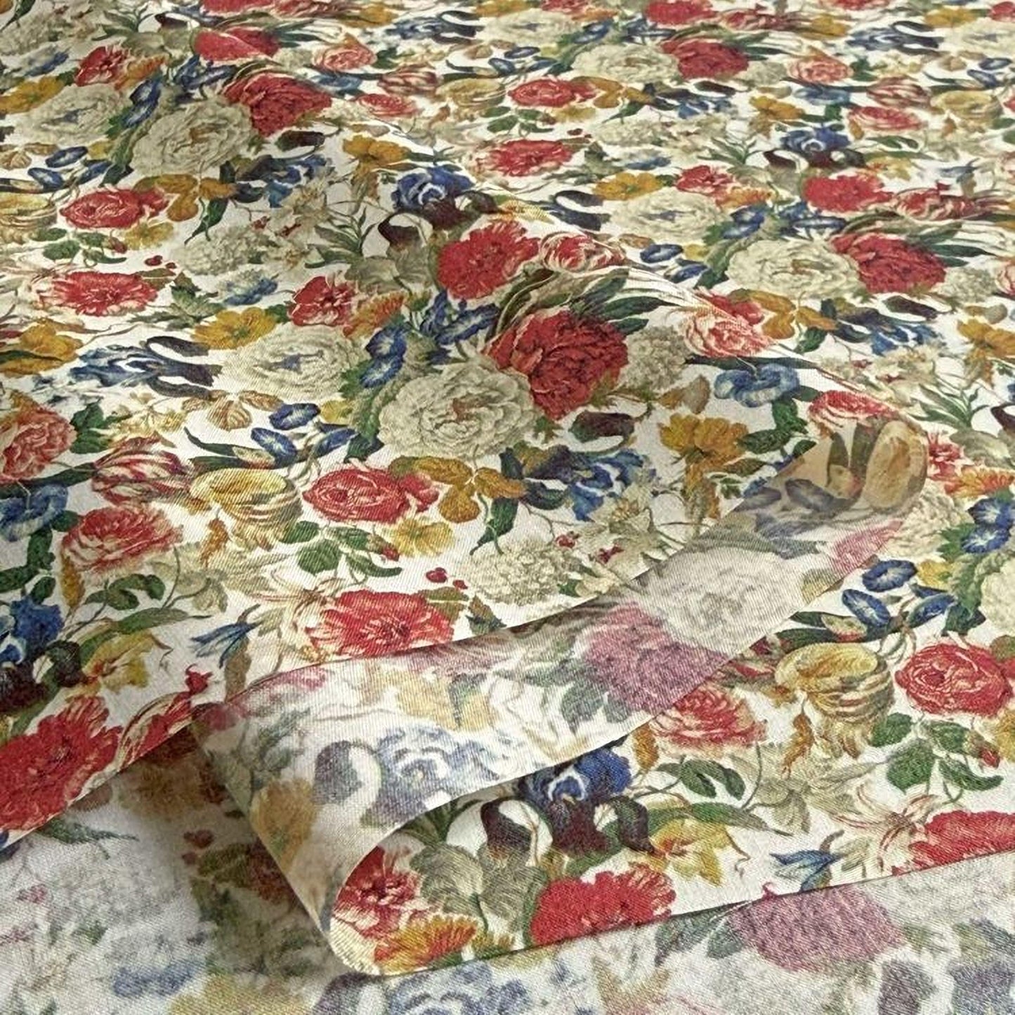 a close-up view of a fabric with a vibrant floral pattern. The fabric is adorned with a variety of colorful flowers, including red, yellow, and white blooms, as well as green leaves and stems. The pattern is intricate and detailed, showcasing the craftsmanship and artistry involved in creating the fabric.