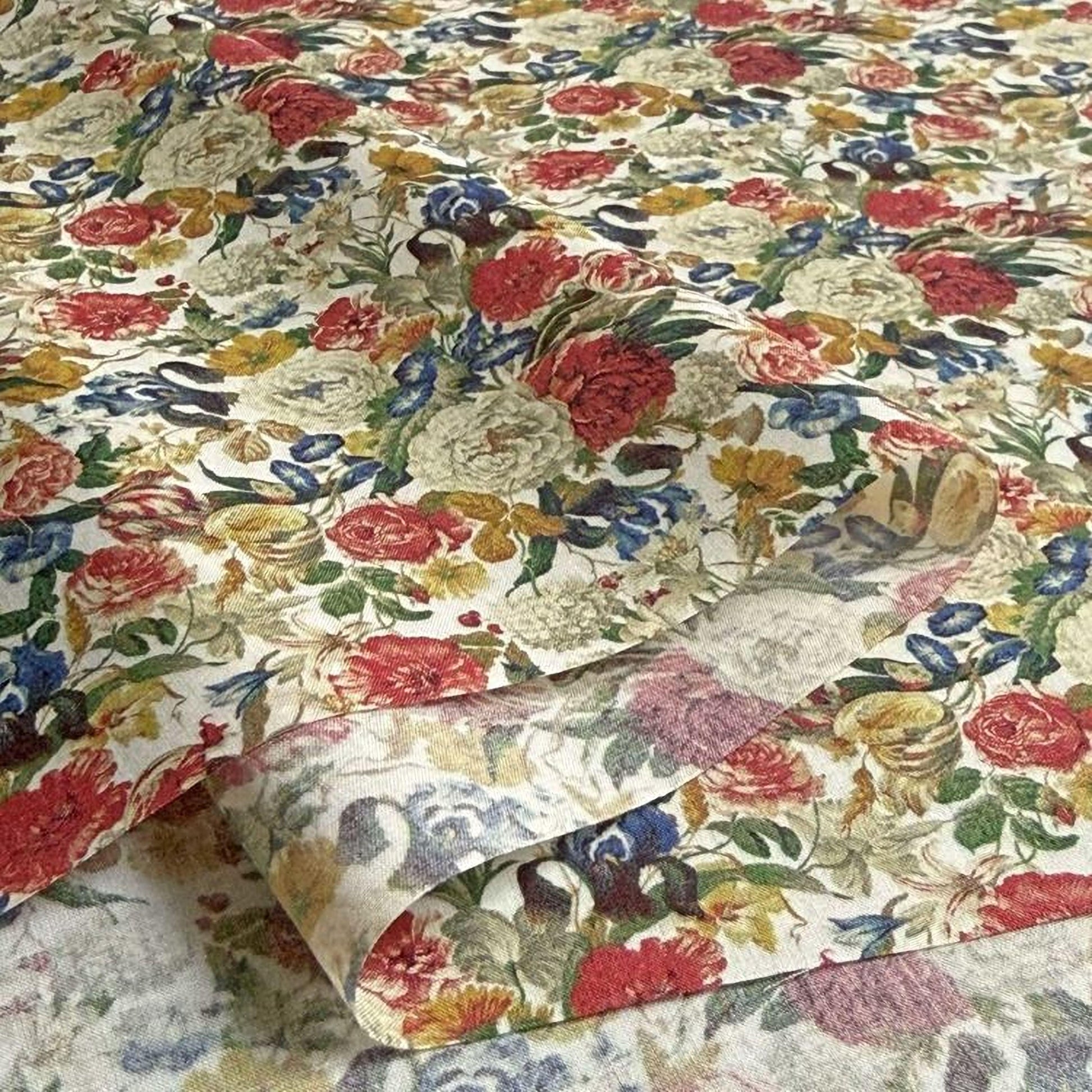 a close-up view of a fabric with a vibrant floral pattern. The fabric is adorned with a variety of colorful flowers, including red, yellow, and white blooms, as well as green leaves and stems. The pattern is intricate and detailed, showcasing the craftsmanship and artistry involved in creating the fabric.
