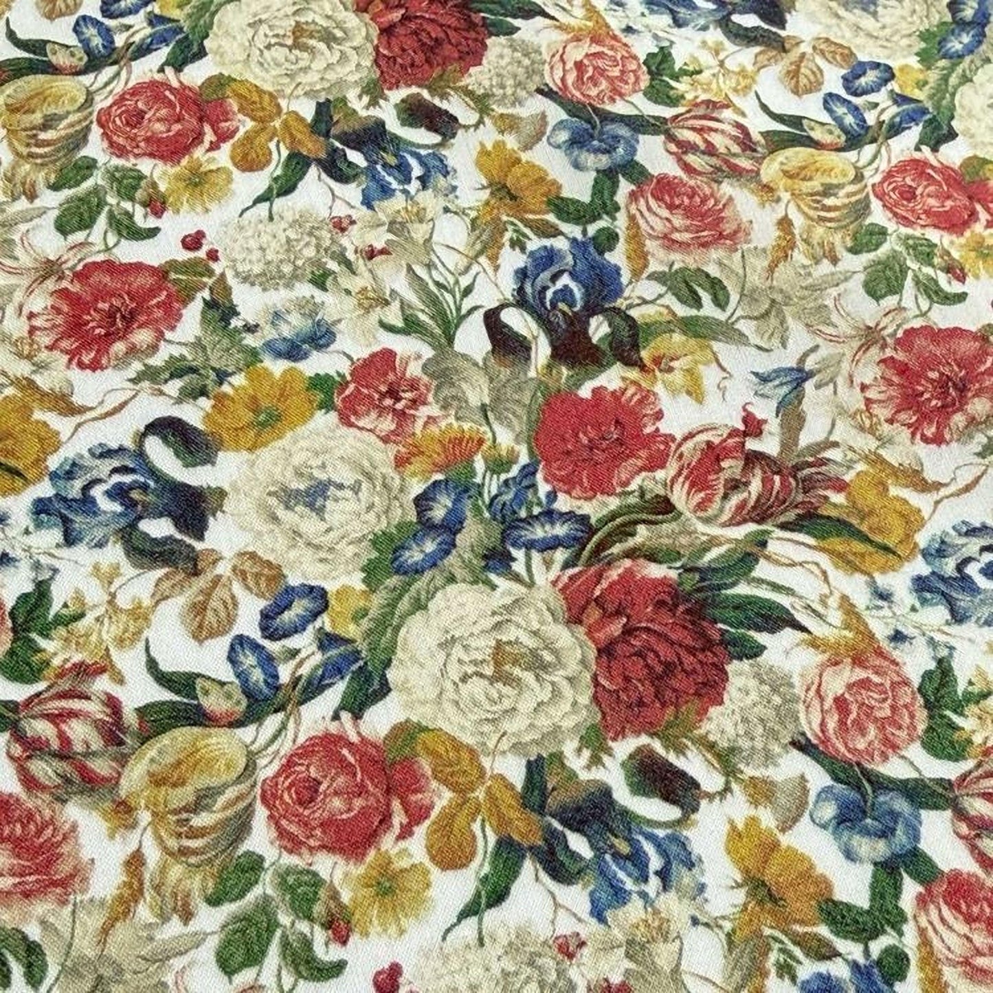 The image is a close-up of a fabric with a vibrant floral pattern, featuring a variety of colorful flowers and leaves.