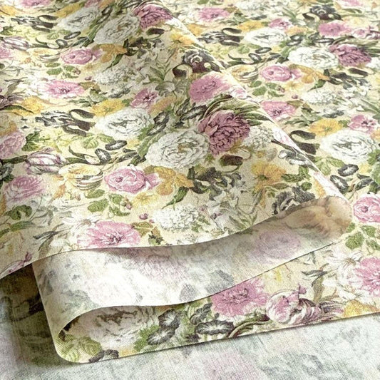 a close-up view of a fabric with a floral pattern, including various shades of pink, white, and green flowers.
