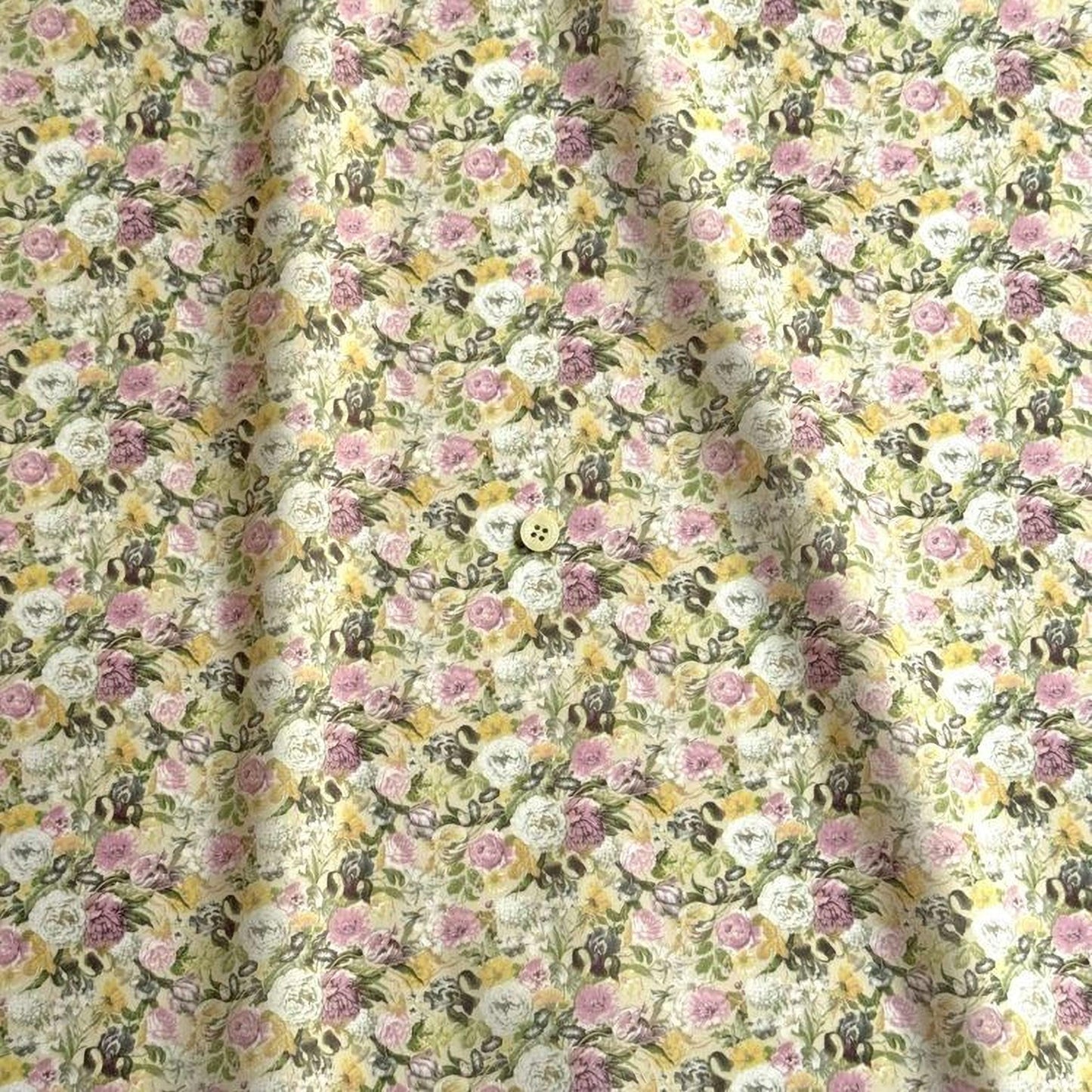 a close-up view of a fabric with a floral pattern, featuring a button in the center.