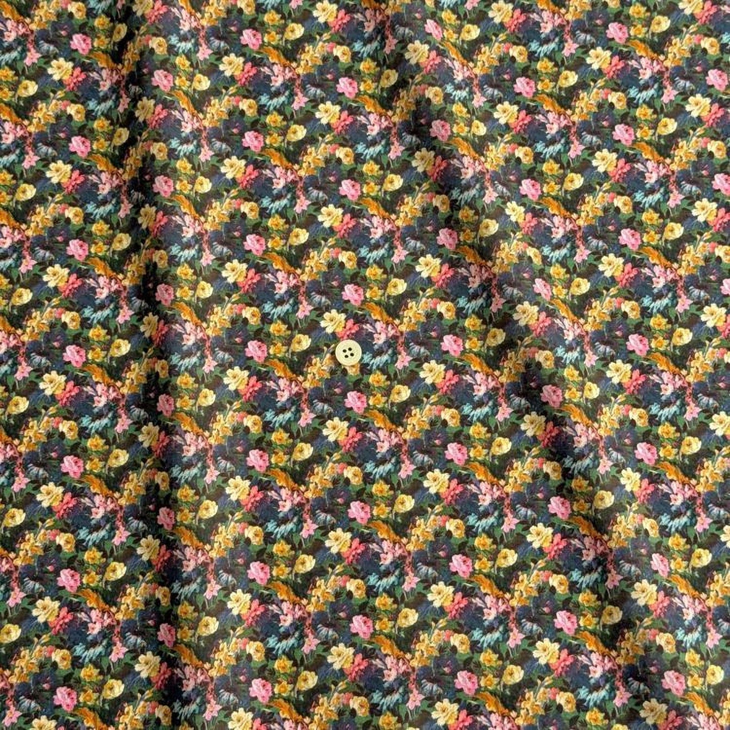 a close-up view of a fabric with a floral pattern, featuring a variety of colorful flowers and leaves.