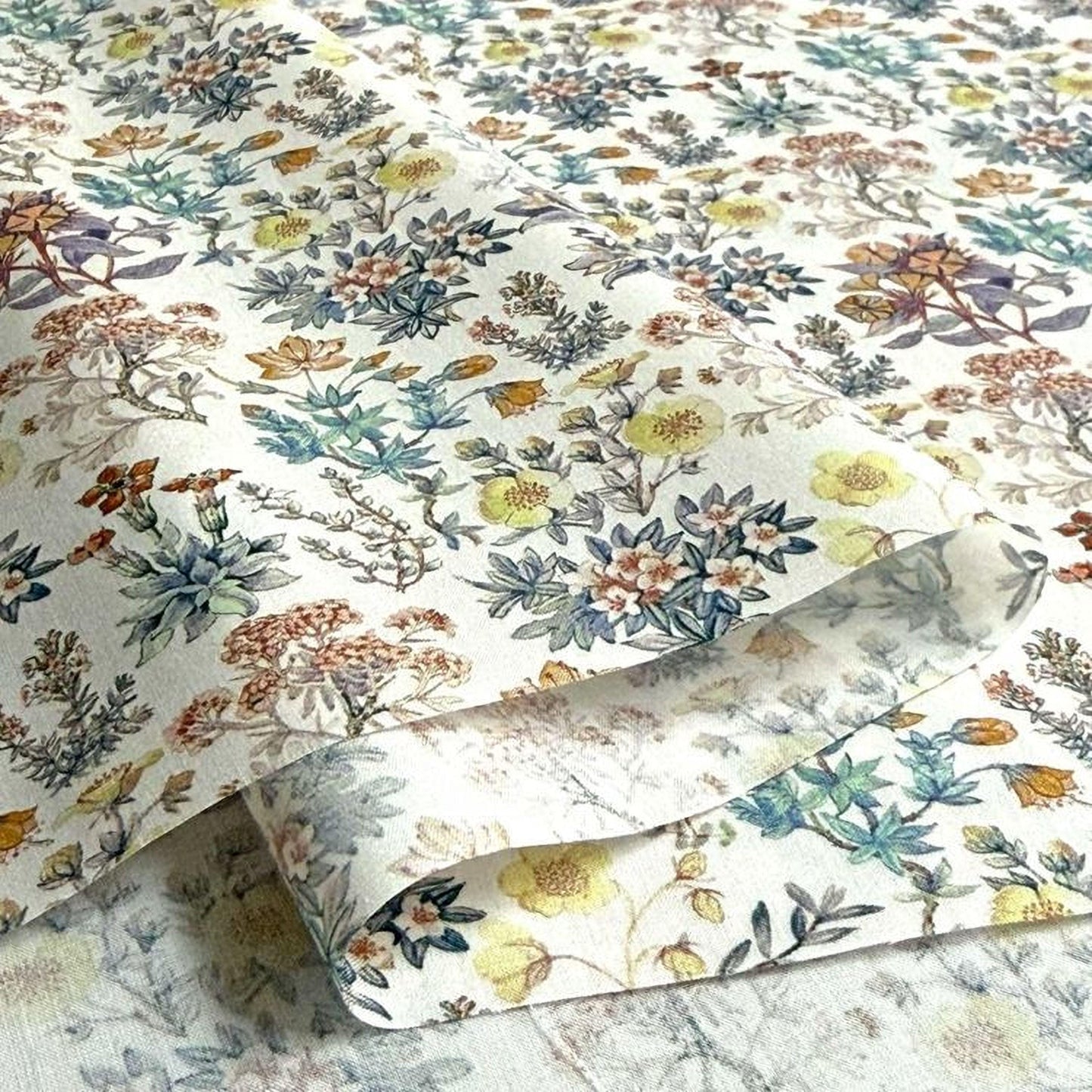 a close-up view of a fabric with a floral pattern, showcasing a variety of colorful flowers and leaves.
